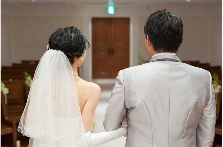 腕を組む新郎新婦の後ろ姿